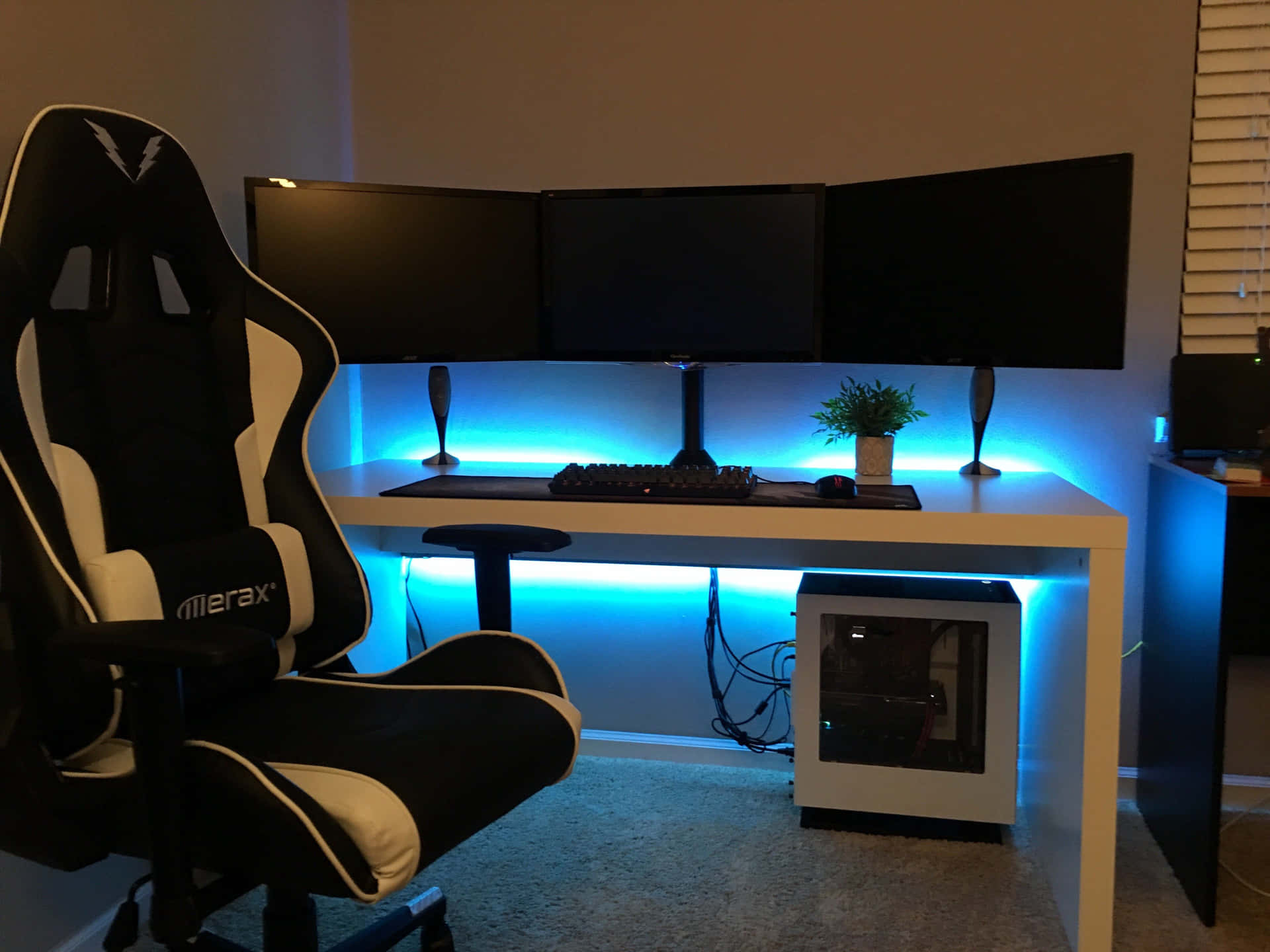 A Gaming Desk With A Chair And Monitors