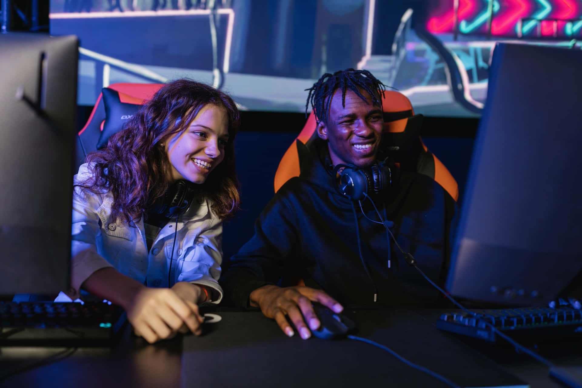Two People Playing Video Games In A Gaming Room
