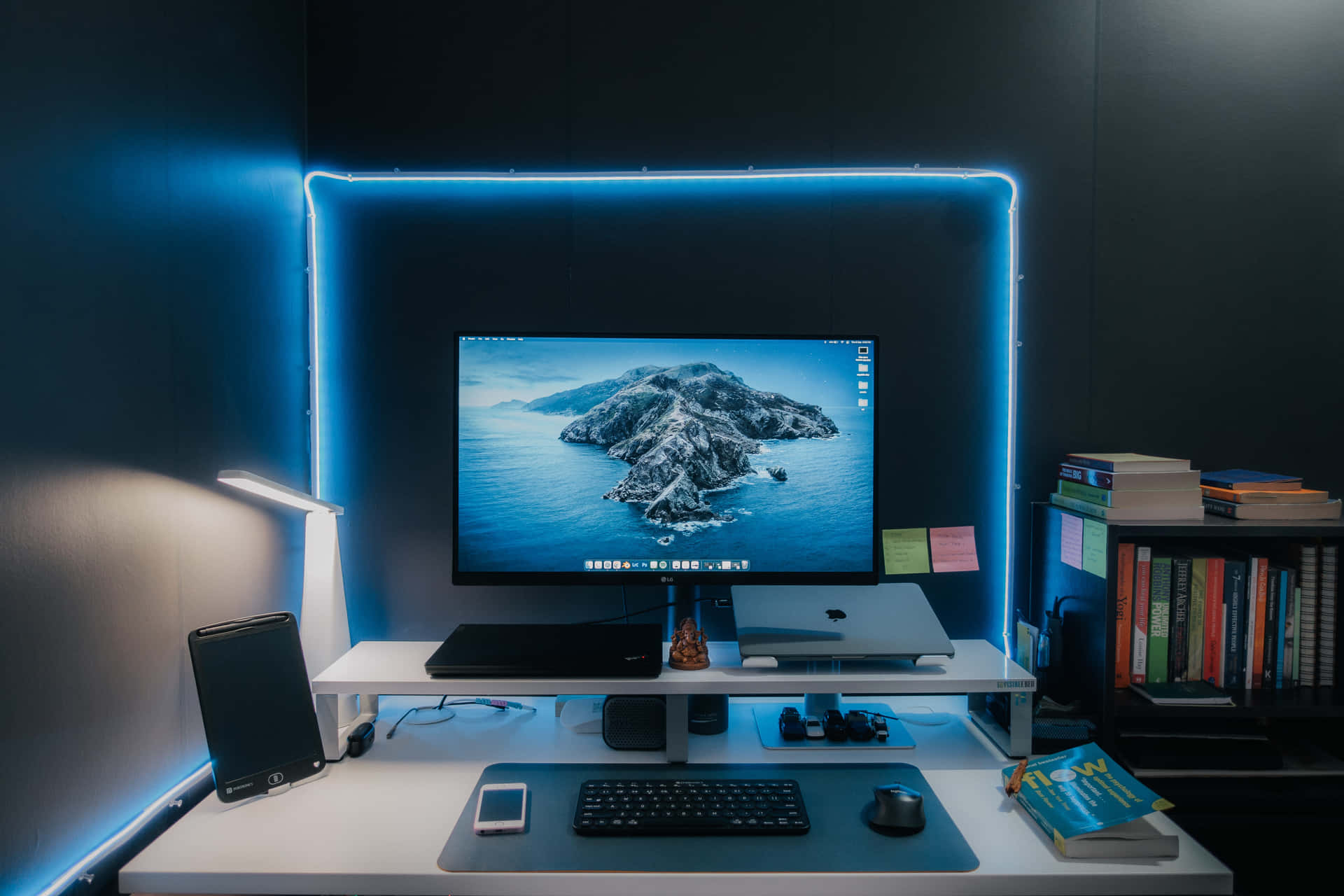 A Computer Desk With Blue Lights And A Monitor