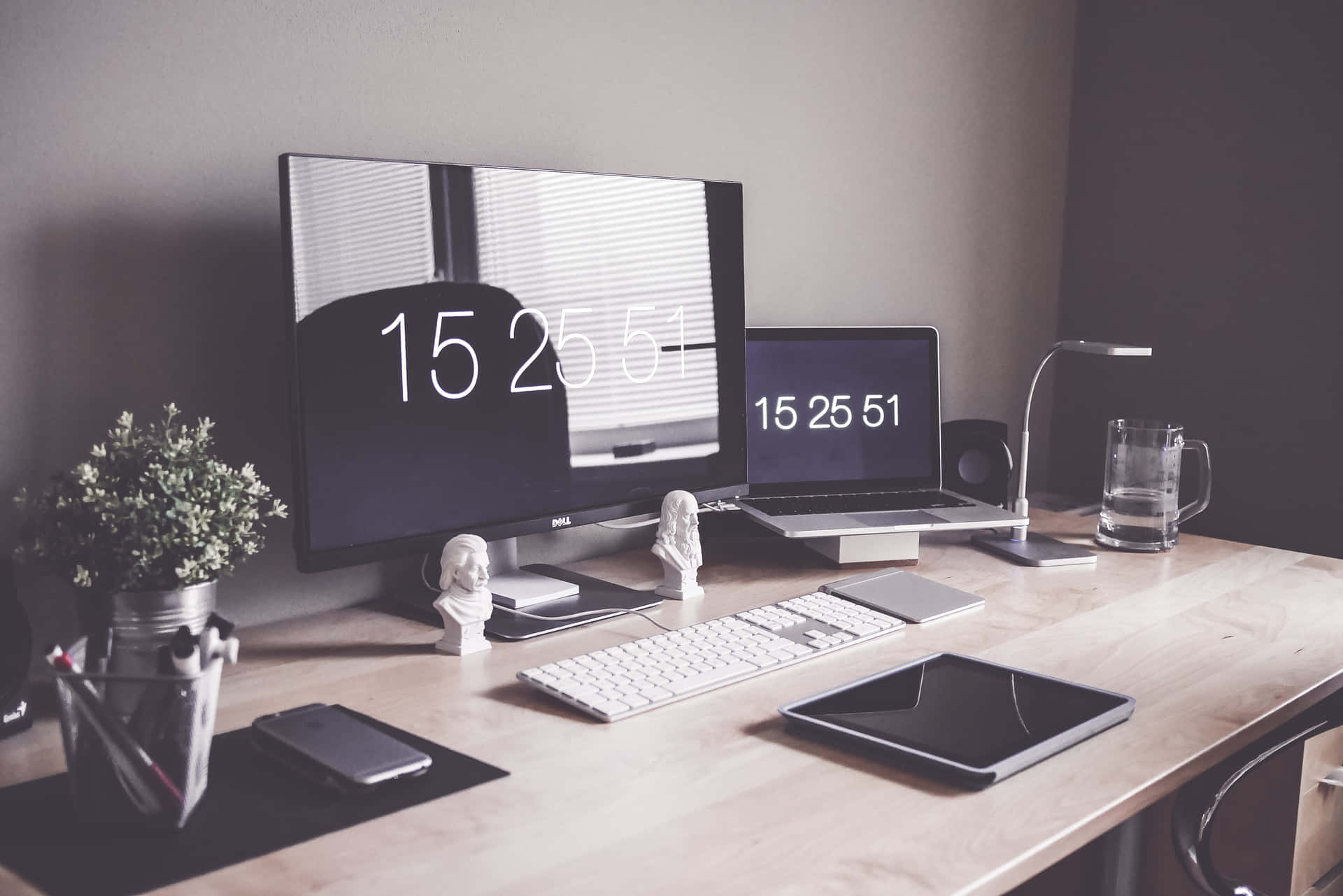 A Desk With A Computer, Monitor, And A Clock