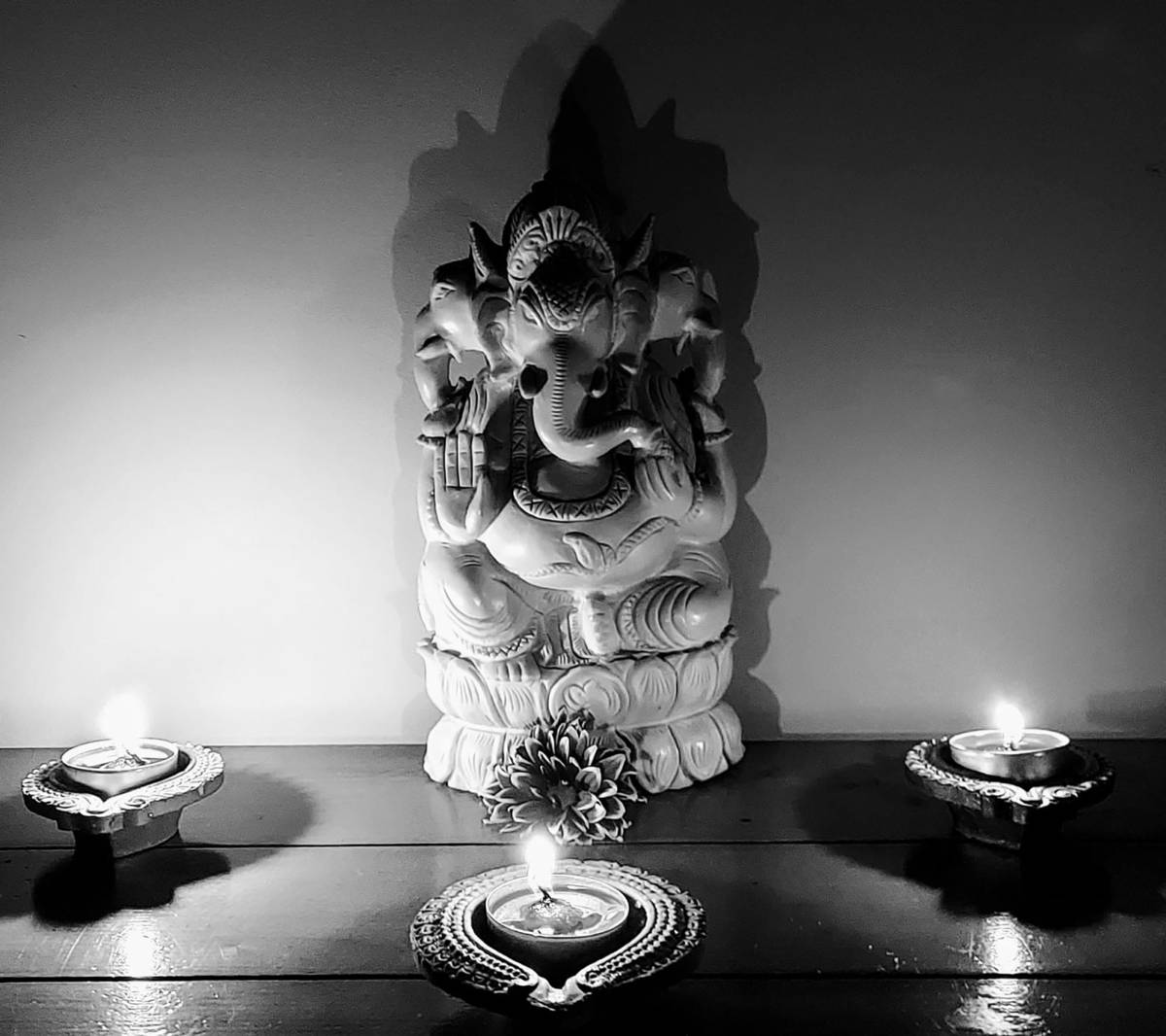 Serene Black and White Illustration of Ganesh Amidst Glowing Candles Wallpaper