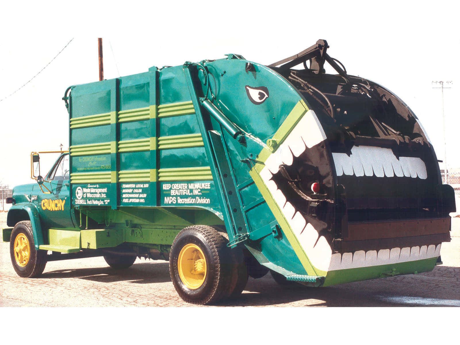 A Green Garbage Truck With A Mouth