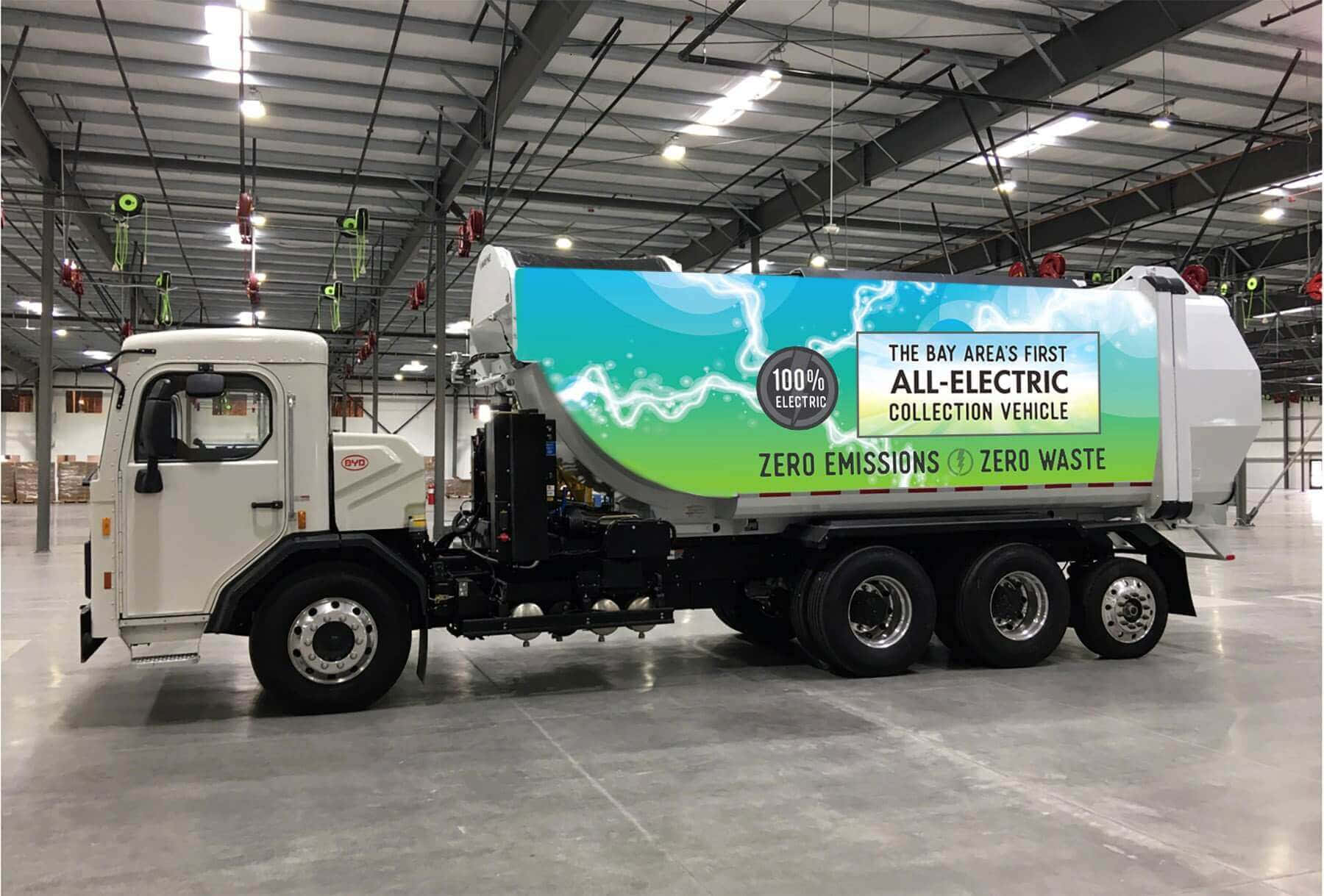 A Large Truck With A Green Banner In The Middle Of A Warehouse