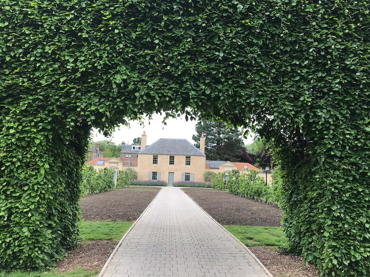 Garden Archway Leadingto House Wallpaper