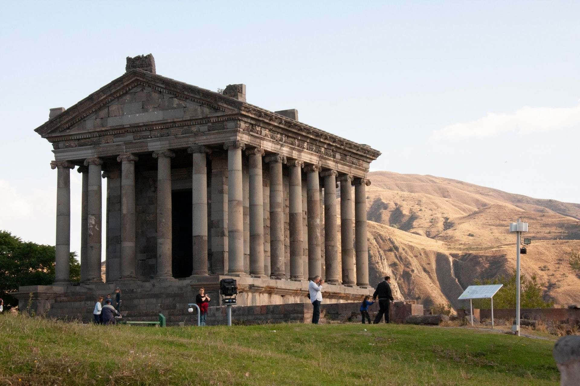 Tourists exploring the ancient Garni Temple in Armenia Wallpaper