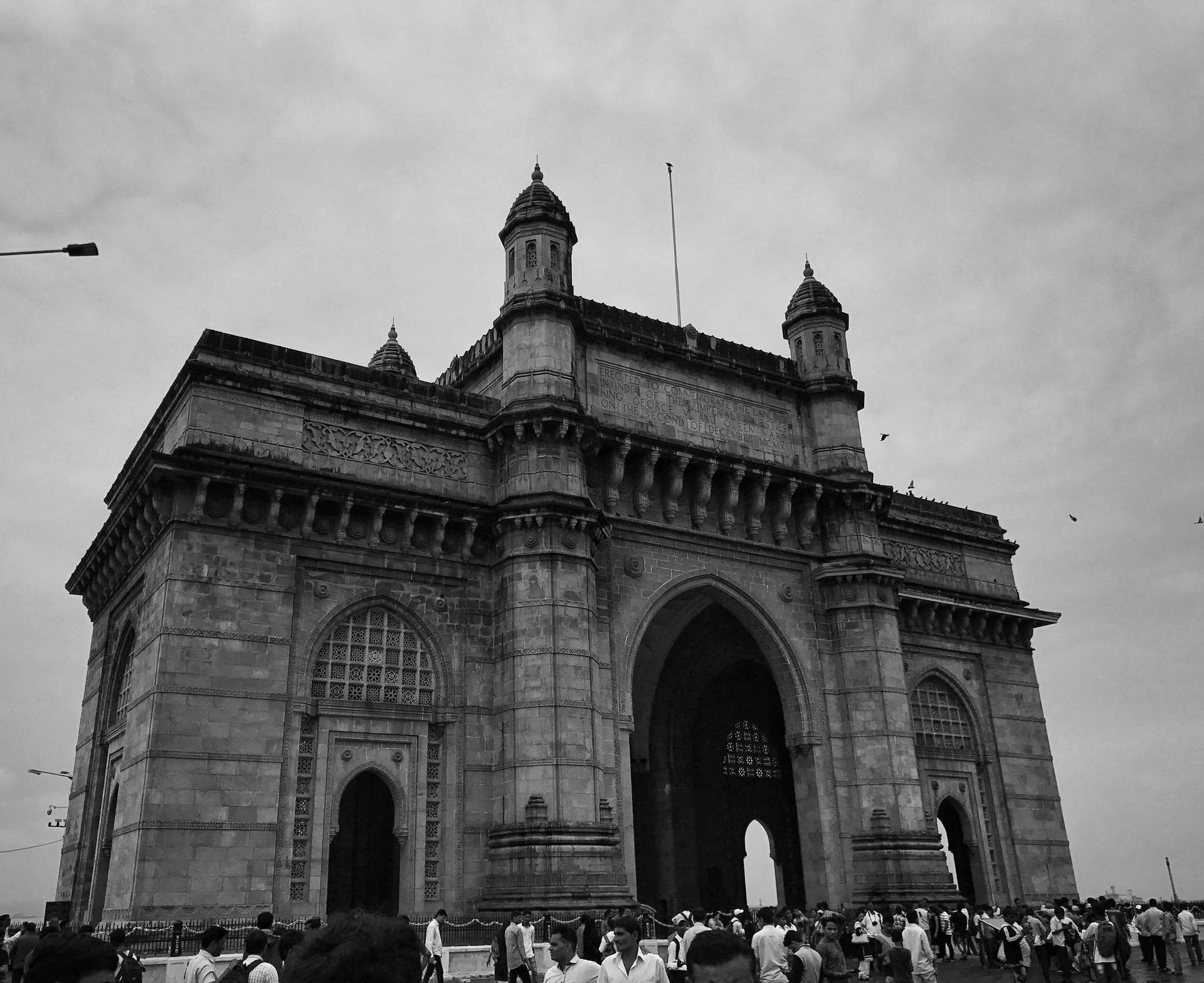 Caption: The Majestic Gateway of Mumbai Under Ambient Skies Wallpaper