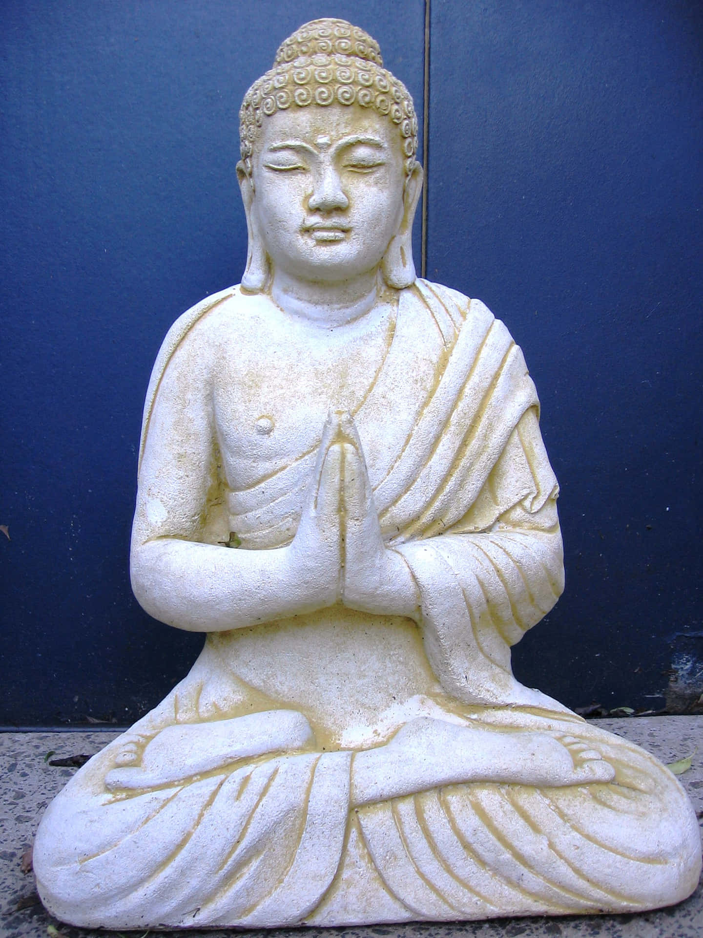 A Buddha Statue Is Sitting On The Ground