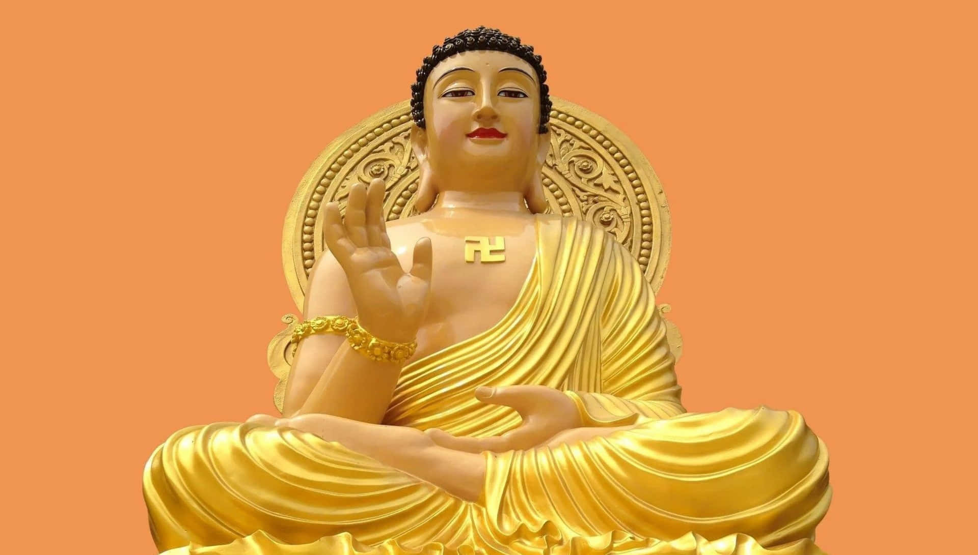 A Gold Buddha Statue Sitting On An Orange Background