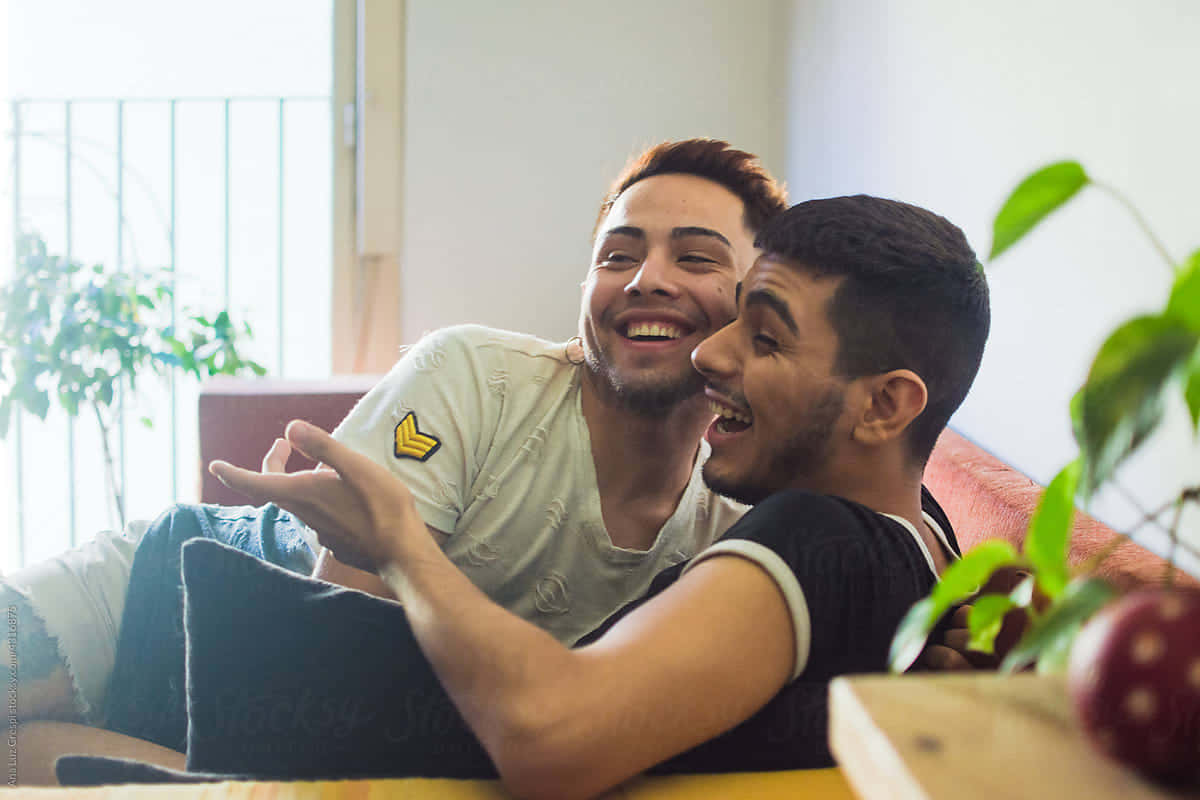 Gay Latino par, der slapper af i deres stue Wallpaper