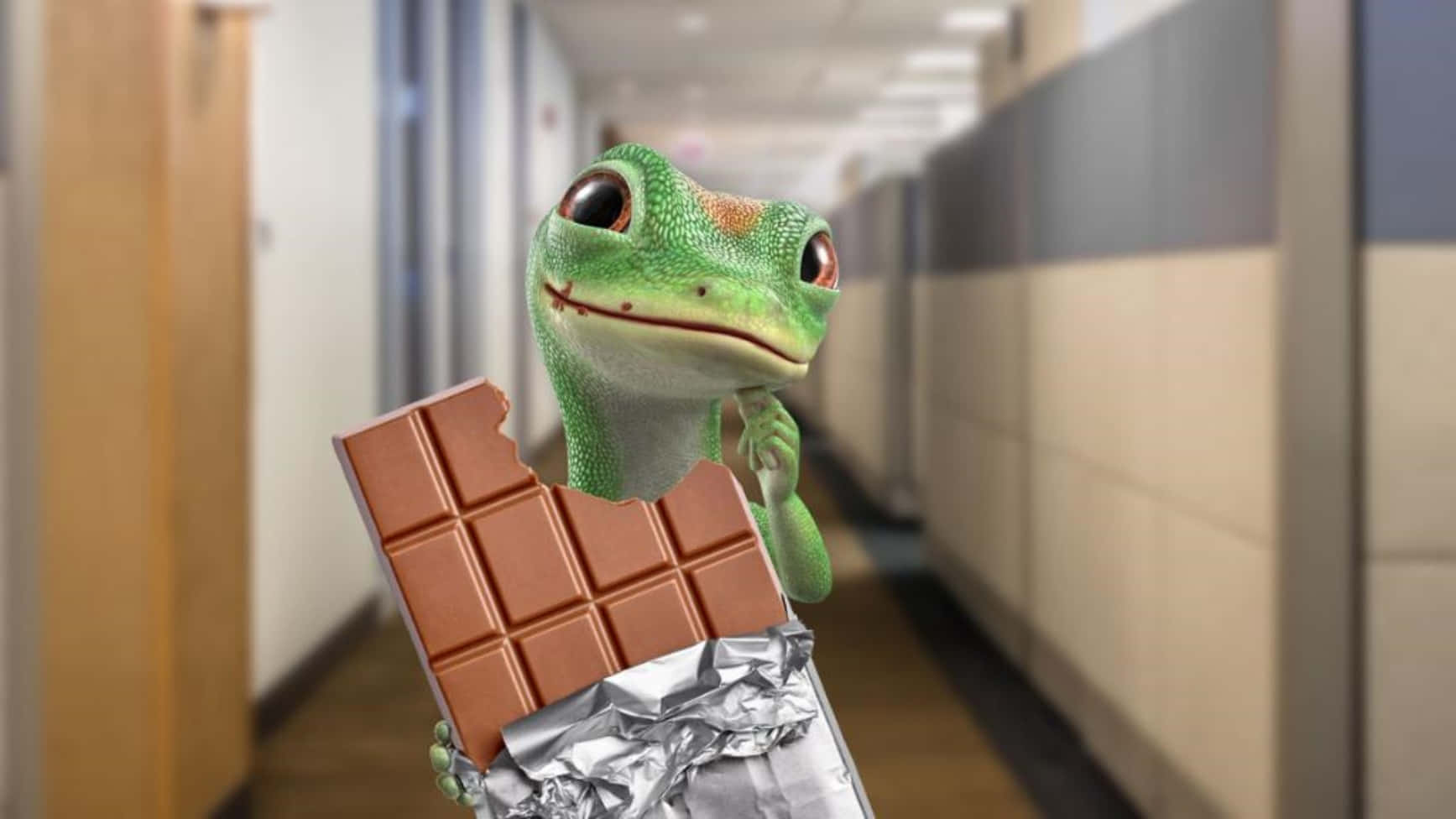 A Lizard Holding A Chocolate Bar In An Office