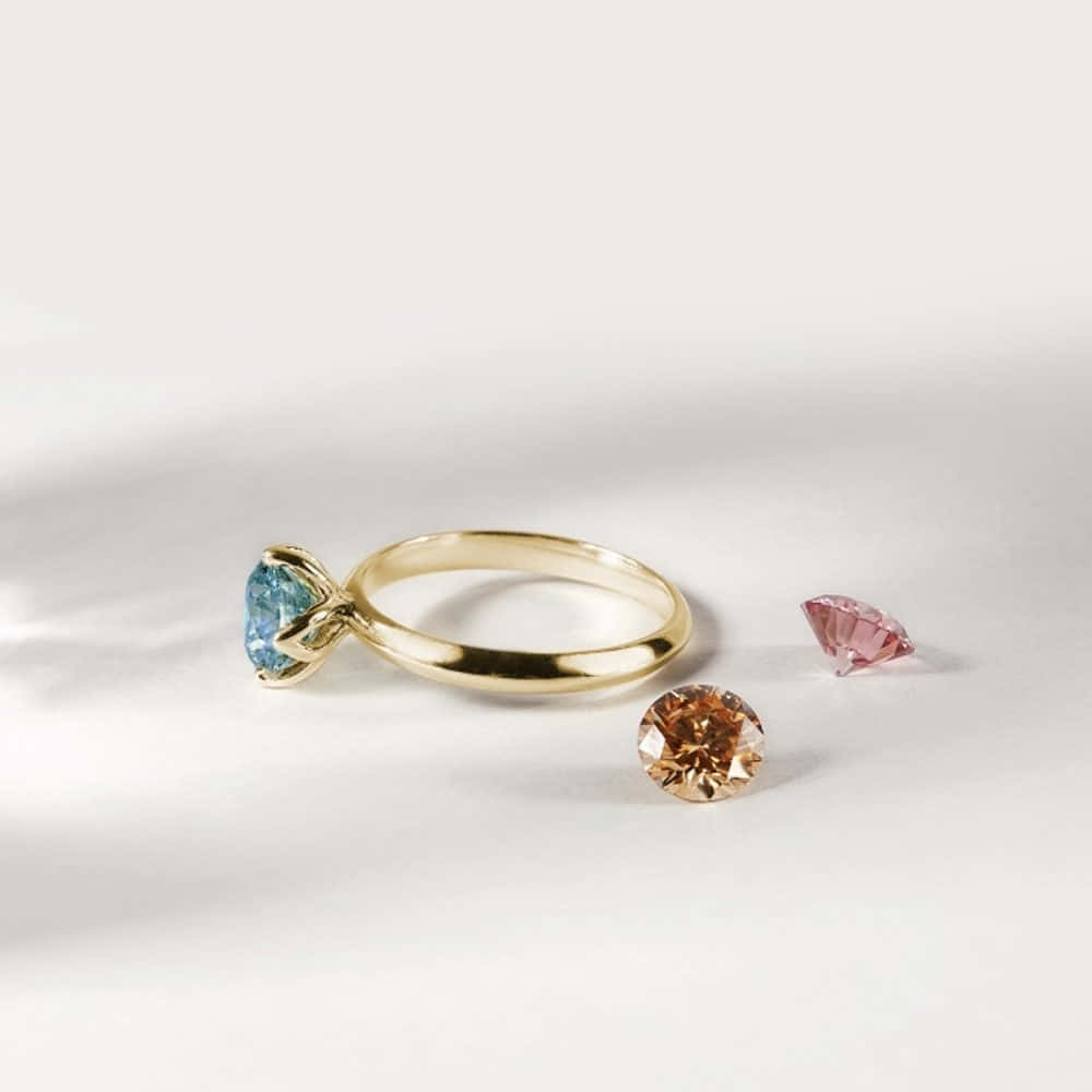 A Gold Ring With A Pink And Blue Diamond