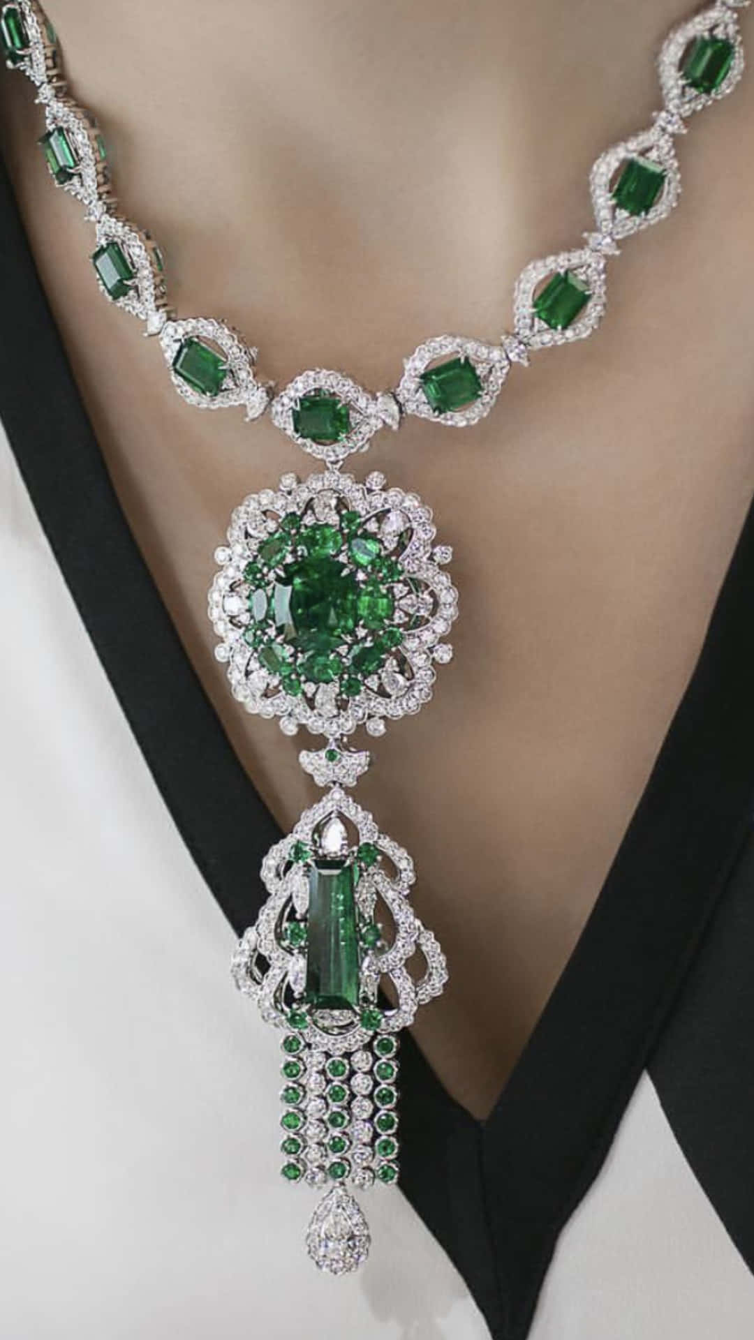 A Woman Wearing A Necklace With Emeralds And Diamonds
