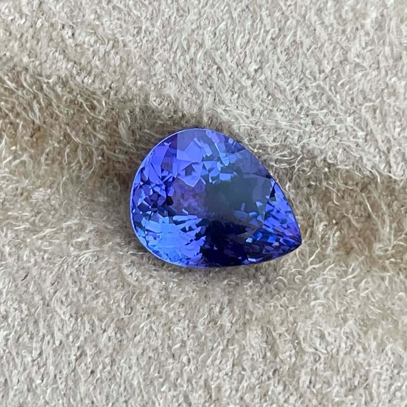 A Blue Tanzanite Gemstone On A White Surface