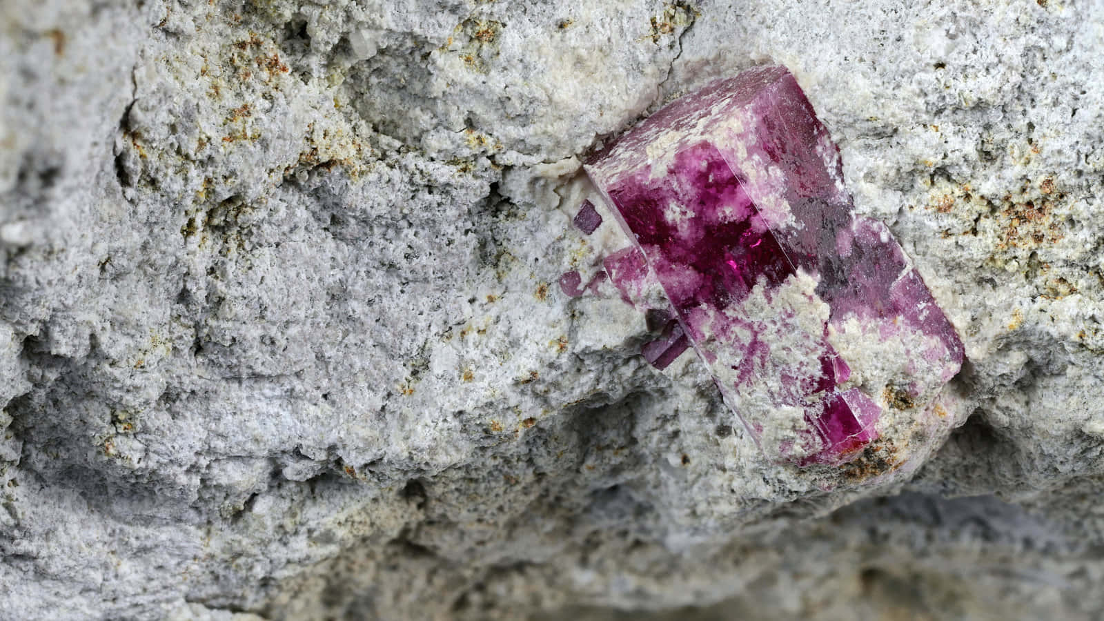 A Piece Of Pink Stone Is Sitting On A Rock