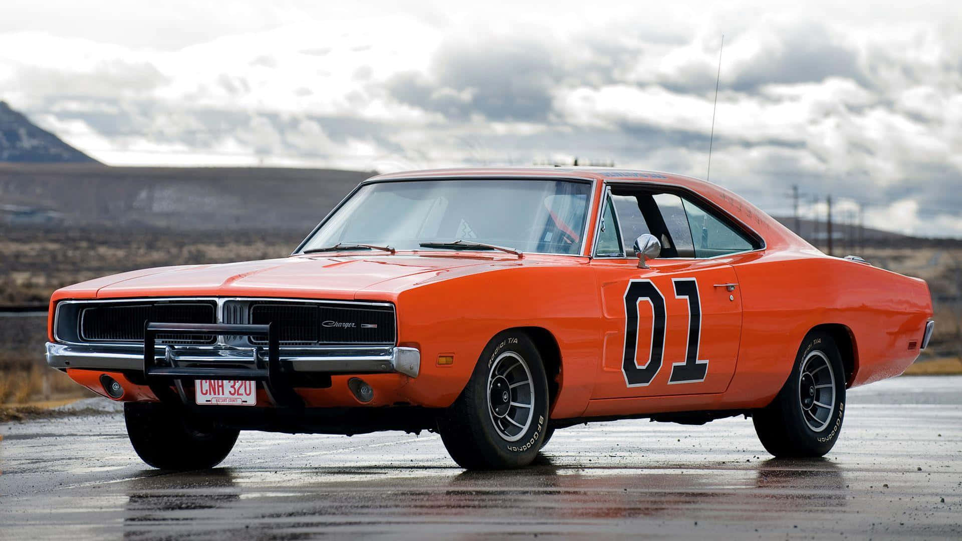 An Orange Dodge Charger Is Parked On The Road Wallpaper