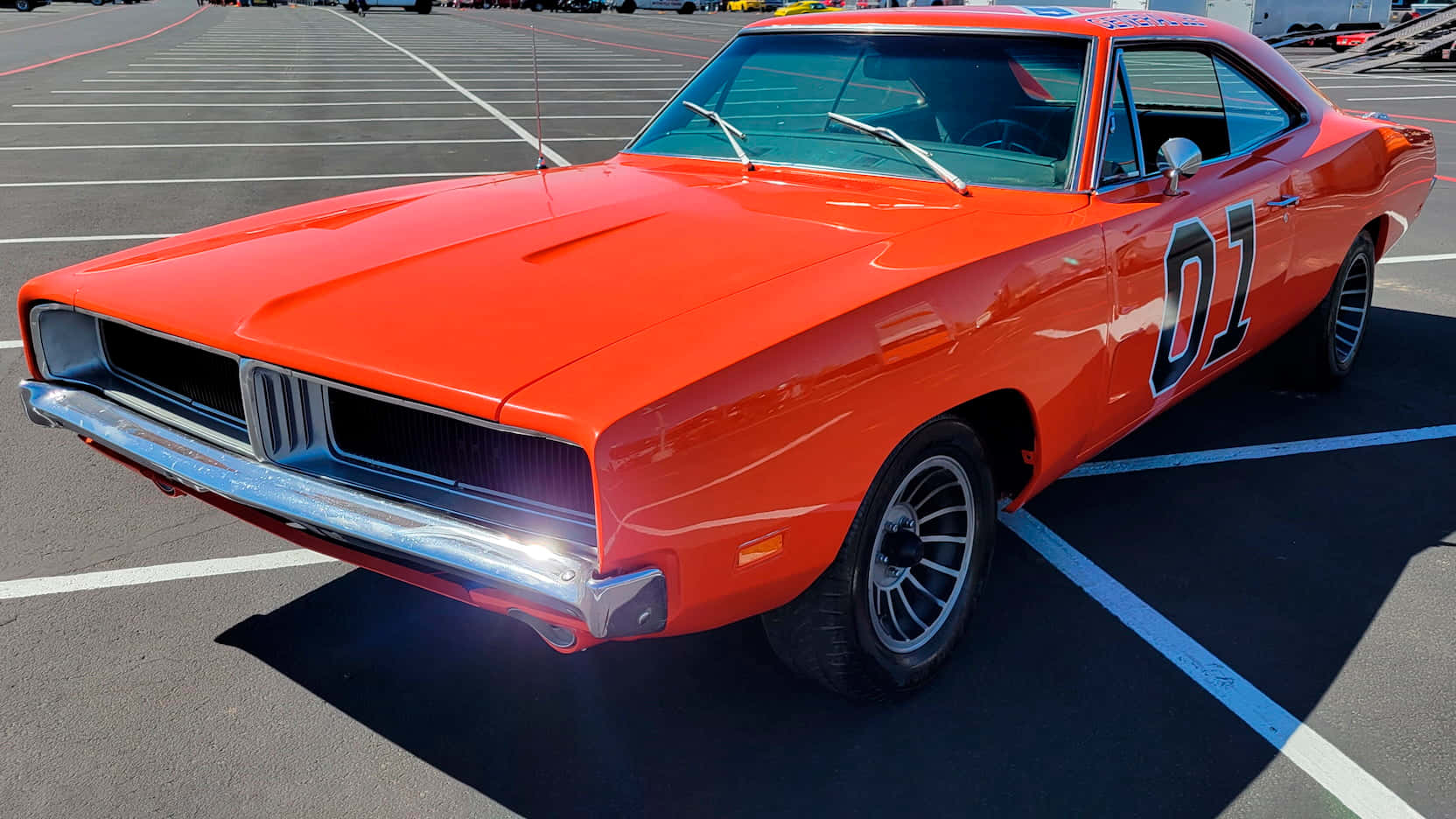 An Orange Dodge Charger Parked In A Parking Lot Wallpaper
