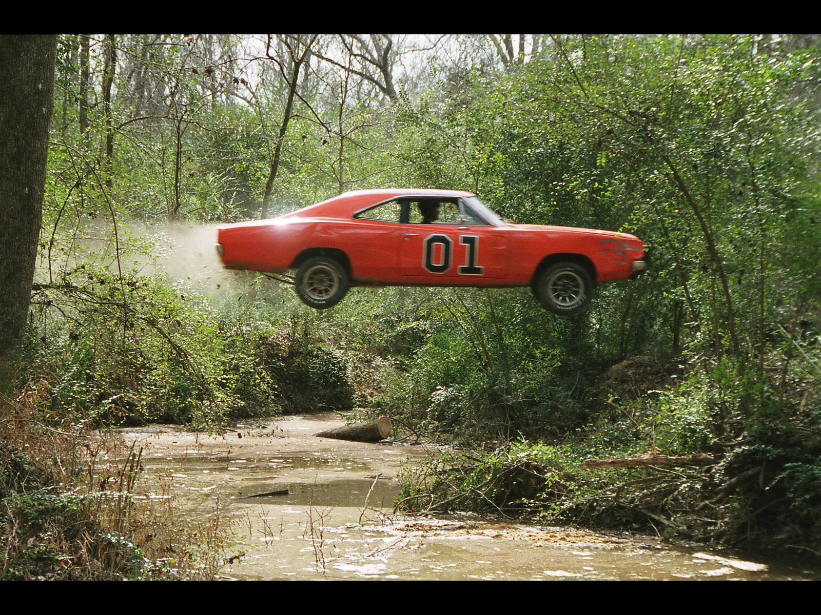 A Car Is Flying Over A Stream Wallpaper