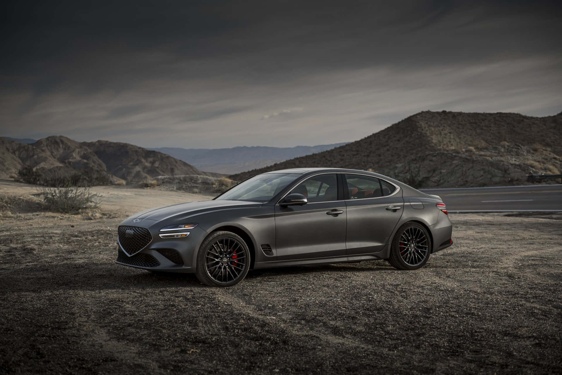 Sleek Genesis G70 driving into the sunset Wallpaper