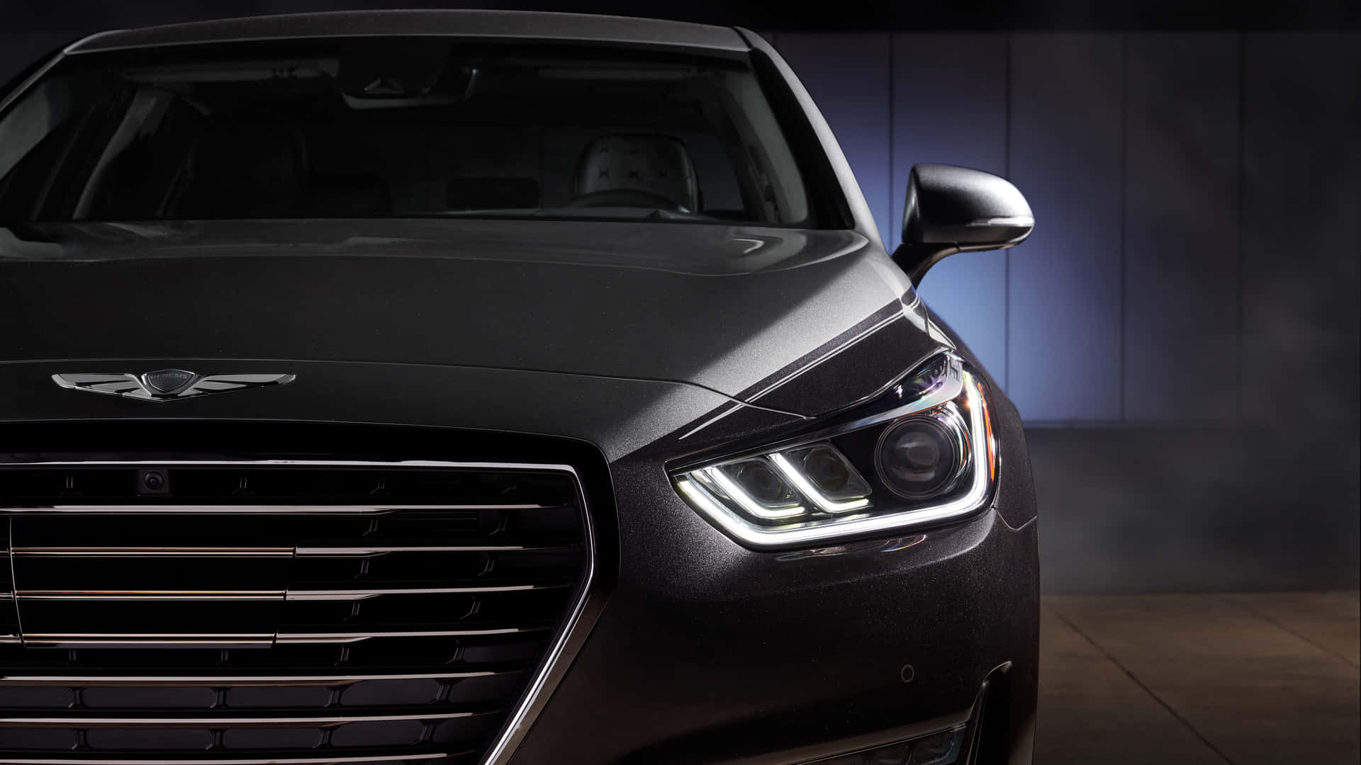 A luxurious Genesis G90 parked on a city street at night Wallpaper