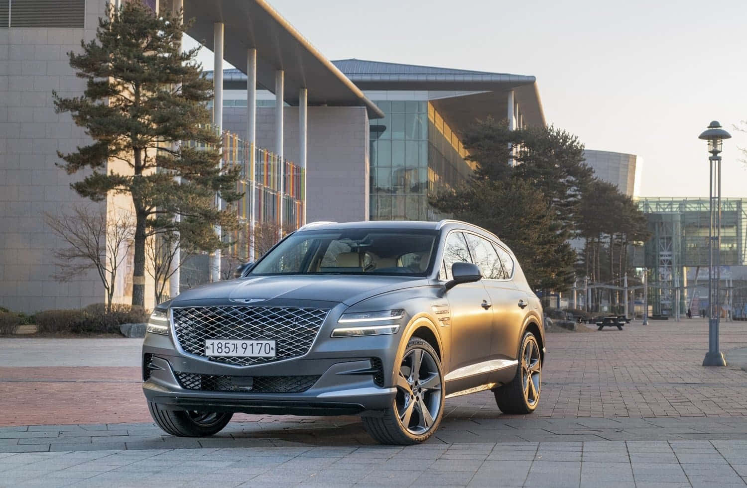 Sleek Genesis GV80 SUV cruising on a highway Wallpaper