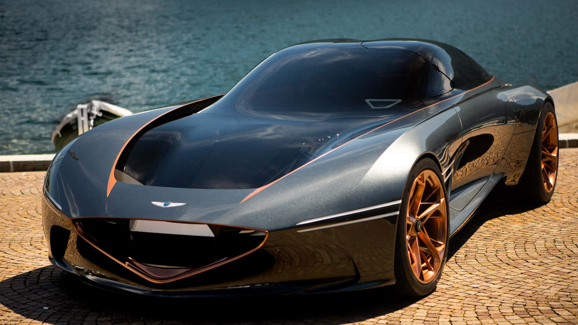 A Black And Gold Sports Car Parked In Front Of A Body Of Water