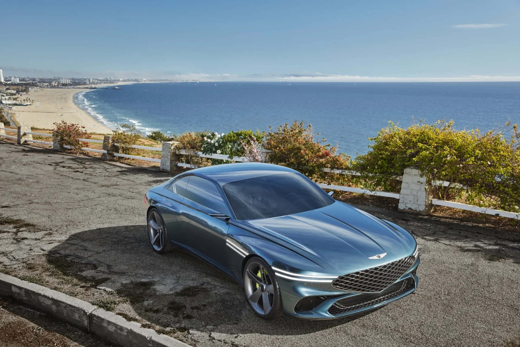 Sleek Genesis X Concept sports car on a scenic coastal road Wallpaper