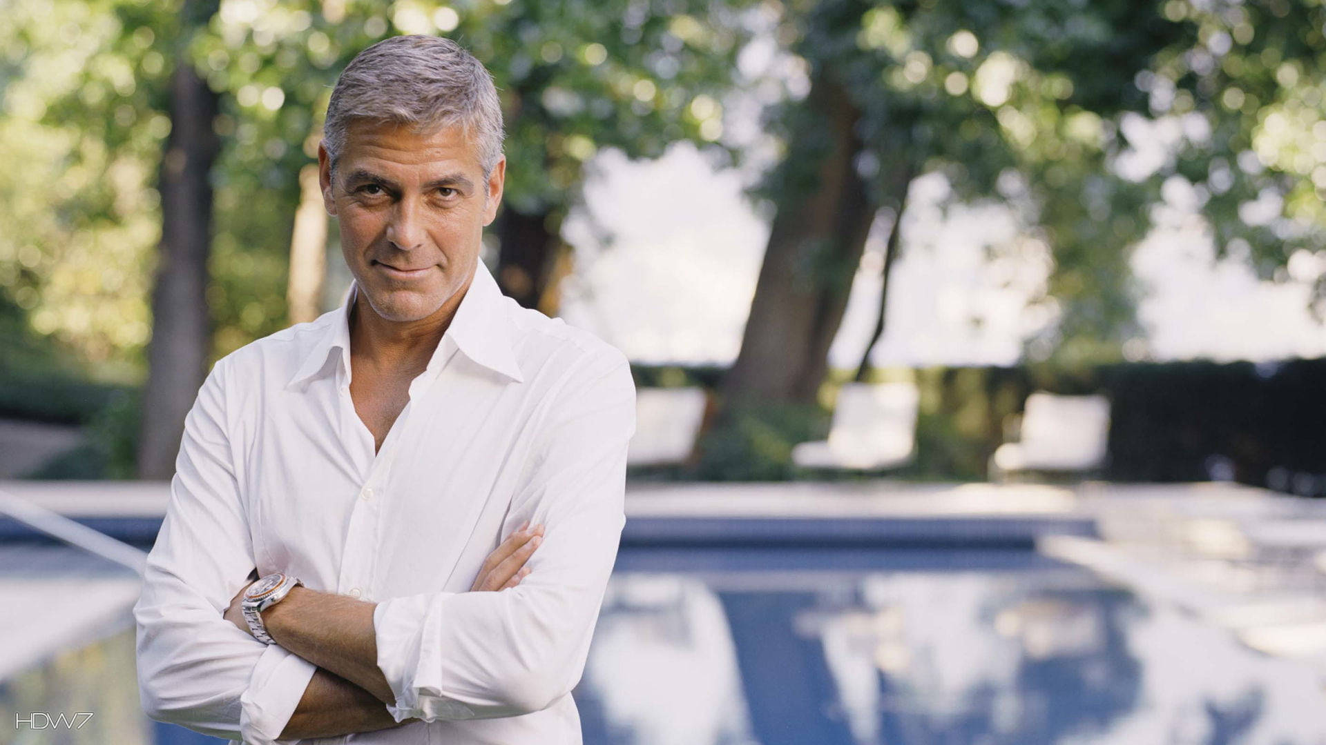 Captivating George Clooney with his Arms Crossed Wallpaper