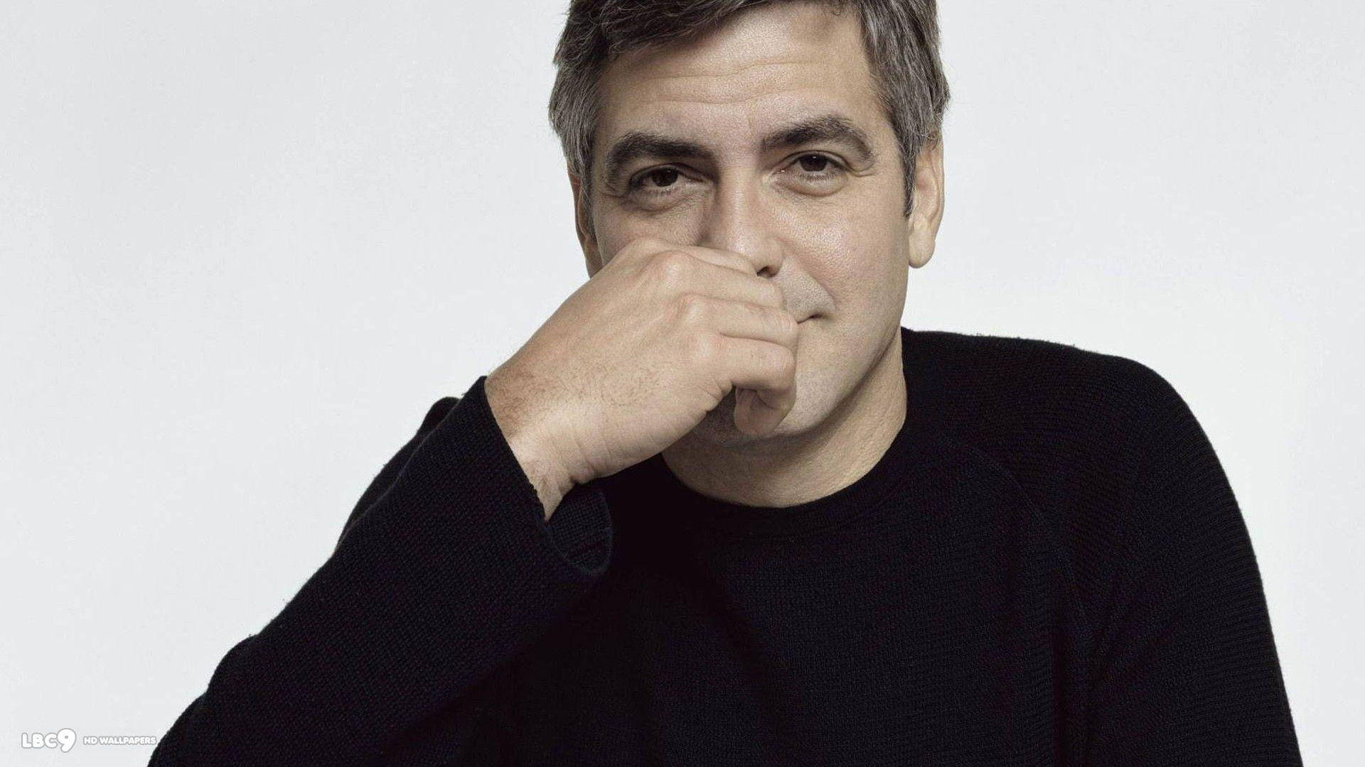 George Clooney Holder Hånden på Ansigtet Wallpaper