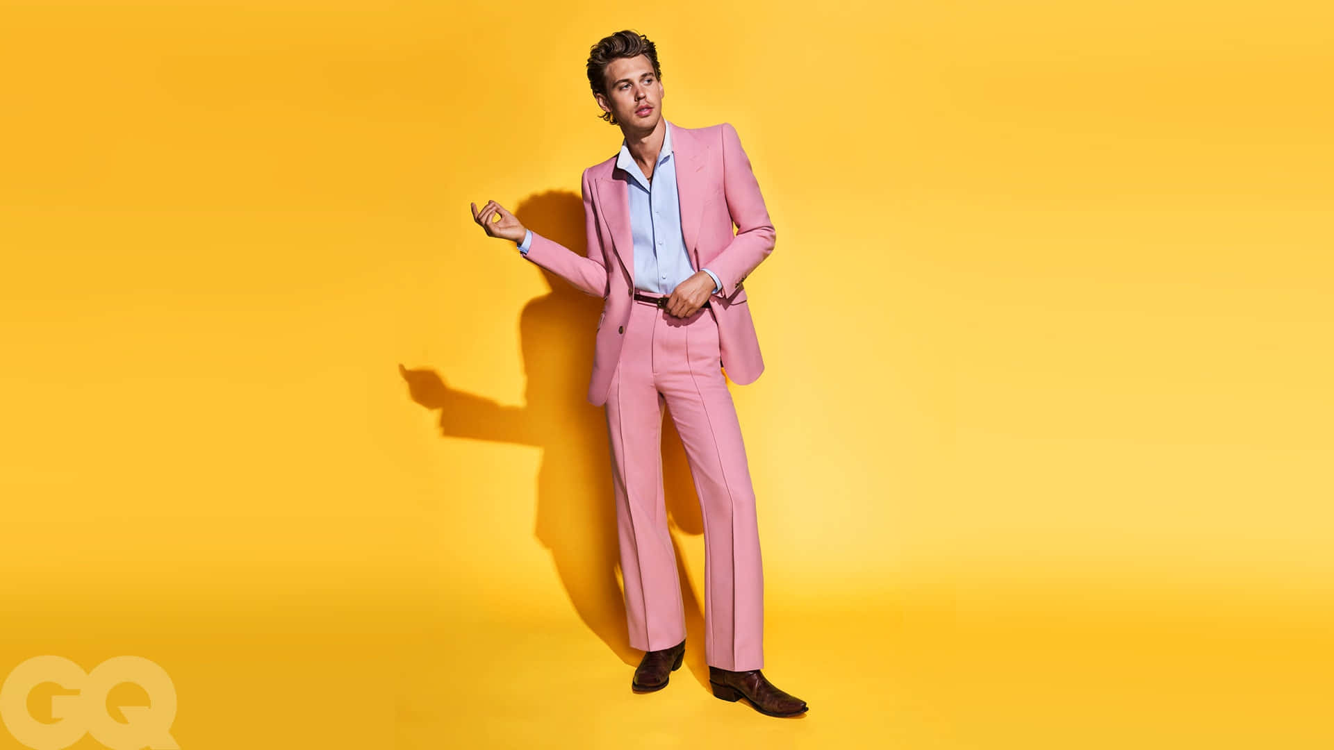 A Man In A Pink Suit Posing Against A Yellow Background Wallpaper