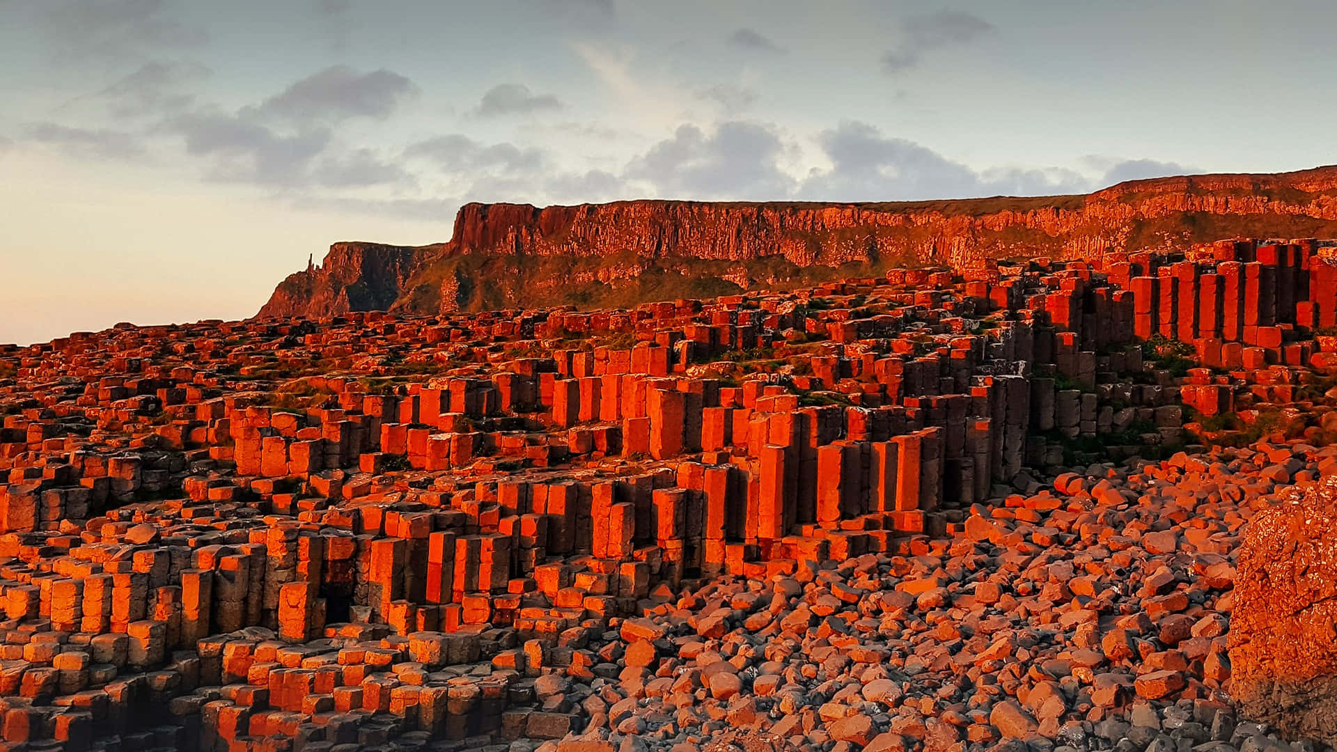 Majestic view of the Giant's Causeway with reddish rocks under the blue sky. Wallpaper