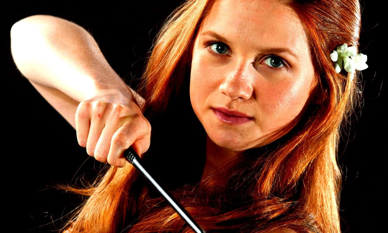 Ginny Weasley casting a spell in a thrilling scene Wallpaper