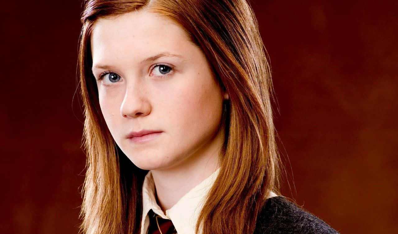 Ginny Weasley casting a spell in the Hogwarts courtyard Wallpaper