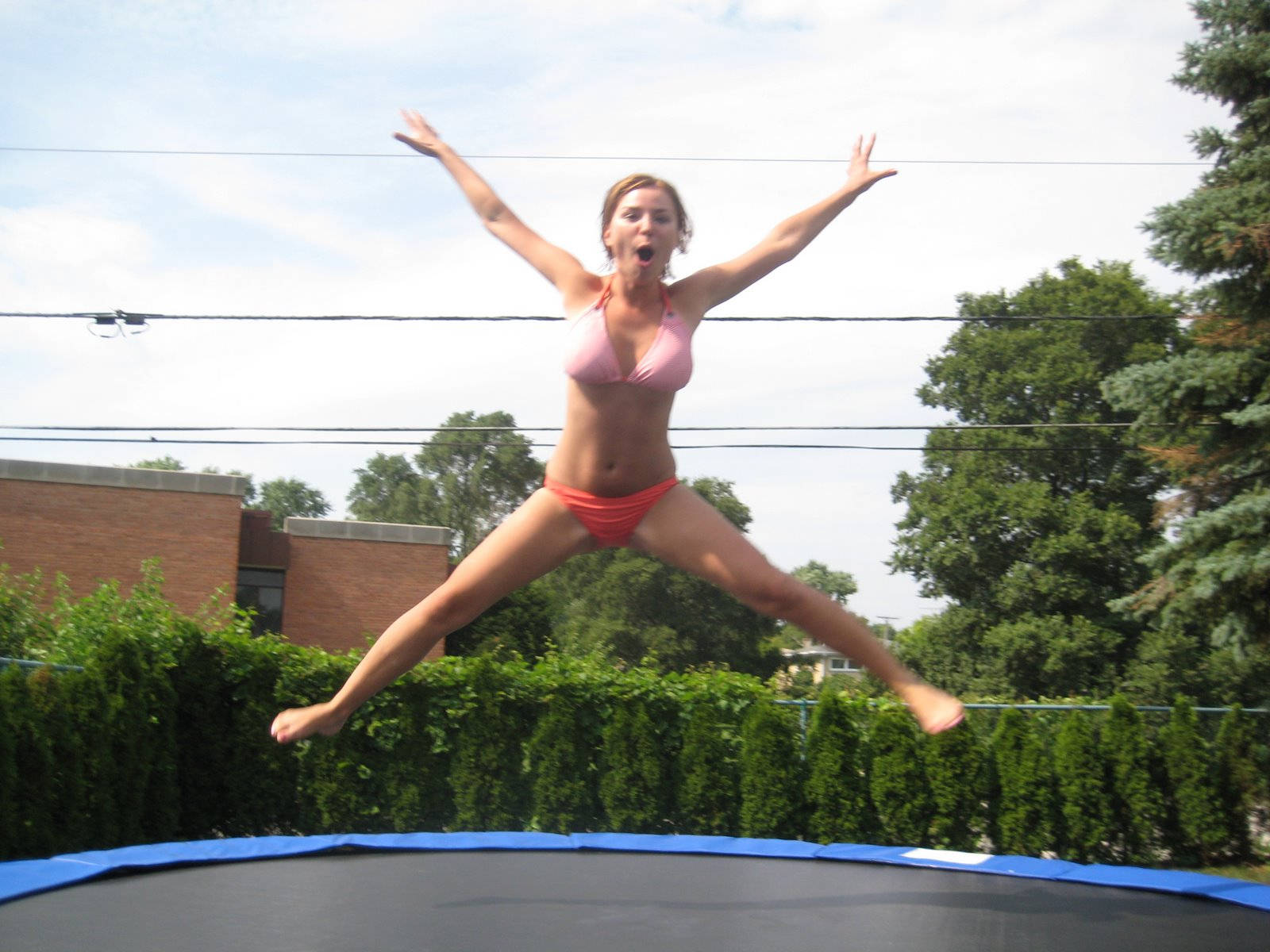 Chicaen Bikini Saltando En Un Trampolín. Fondo de pantalla