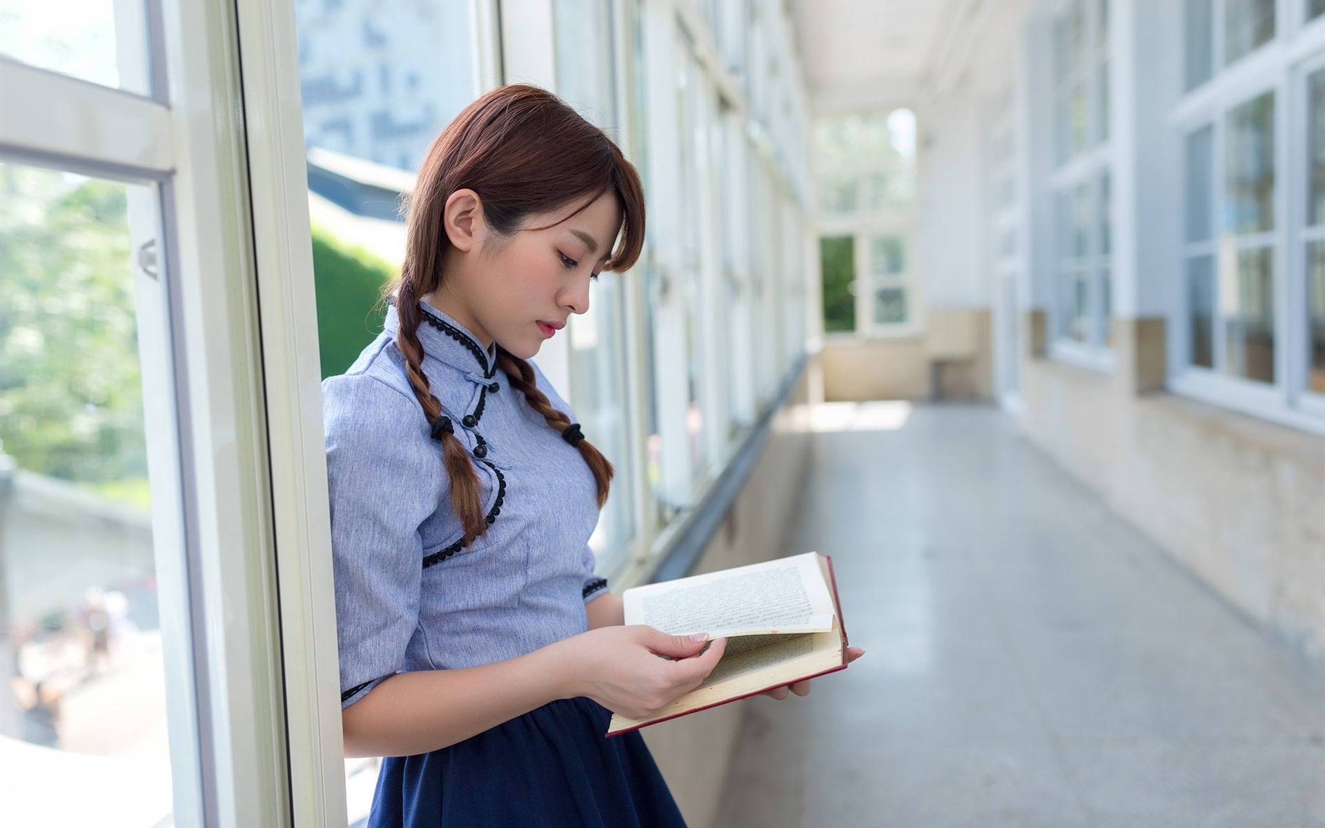 Girl Student Reading In Corridor Wallpaper