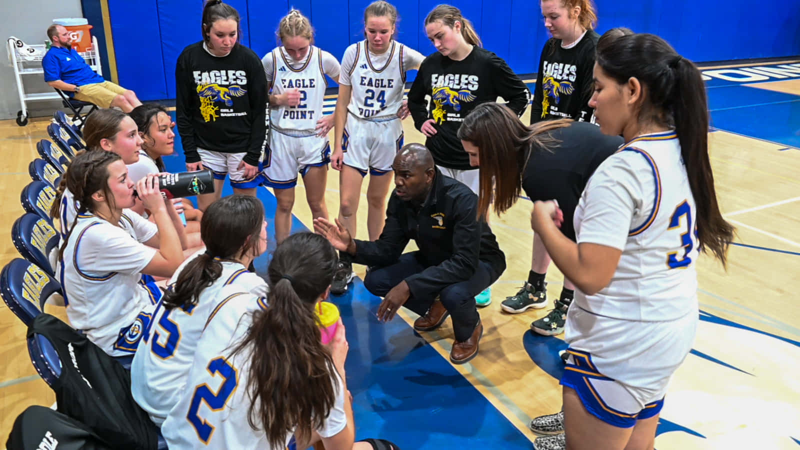 Girls Basketball Team Huddle With Coach Wallpaper