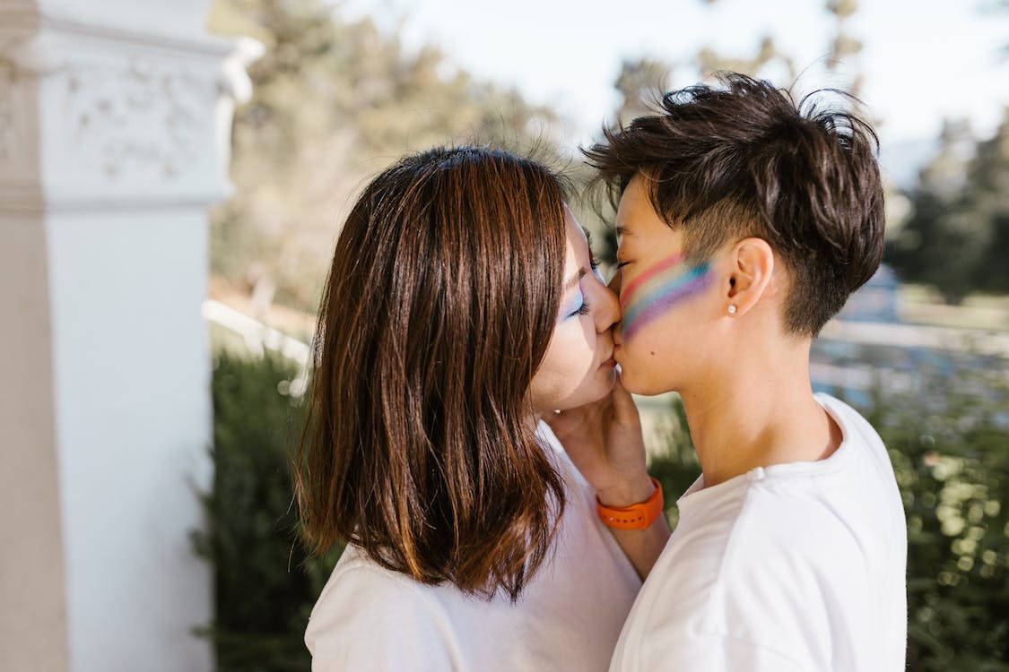 Flickorsom Kysser Med Regnbågsansiktsmålning. Wallpaper