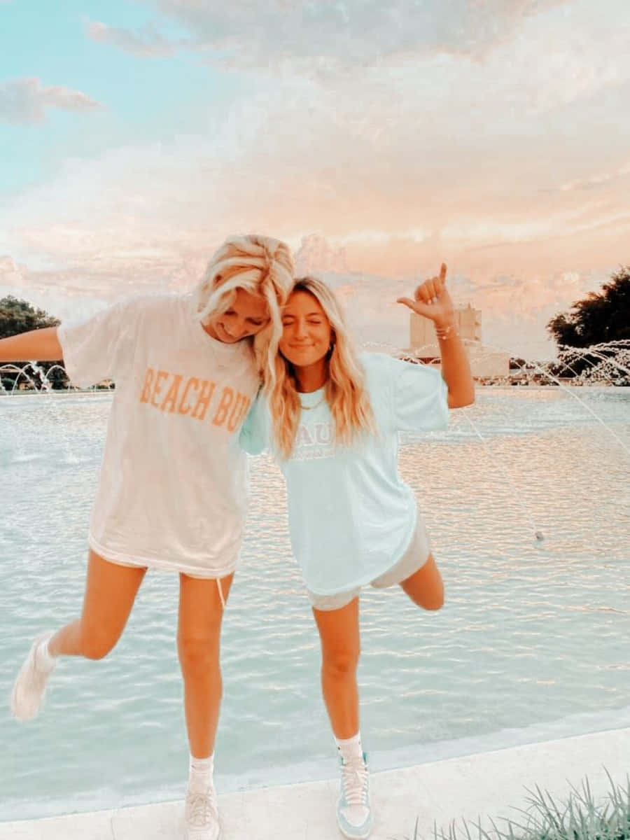 Two Girls In T - Shirts Standing Next To A Pool