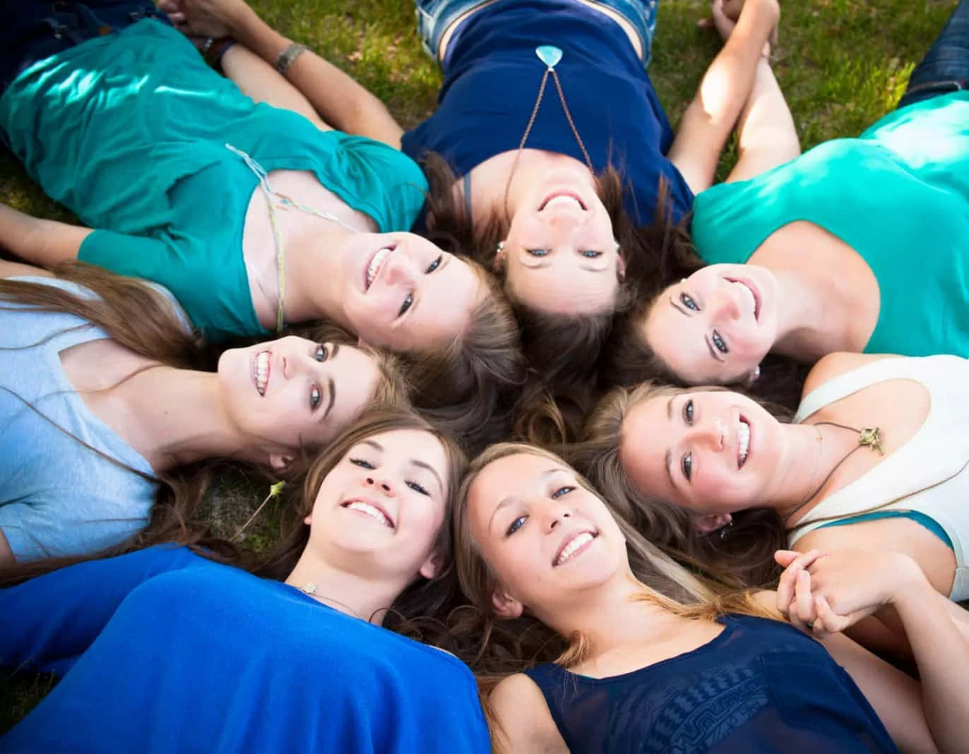 A Group Of Girls Laying On The Grass