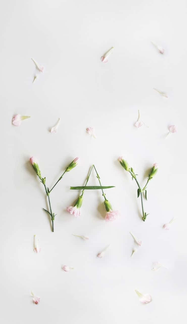 En hvid baggrund med pink blomster arrangeret i form af ordet yay Wallpaper