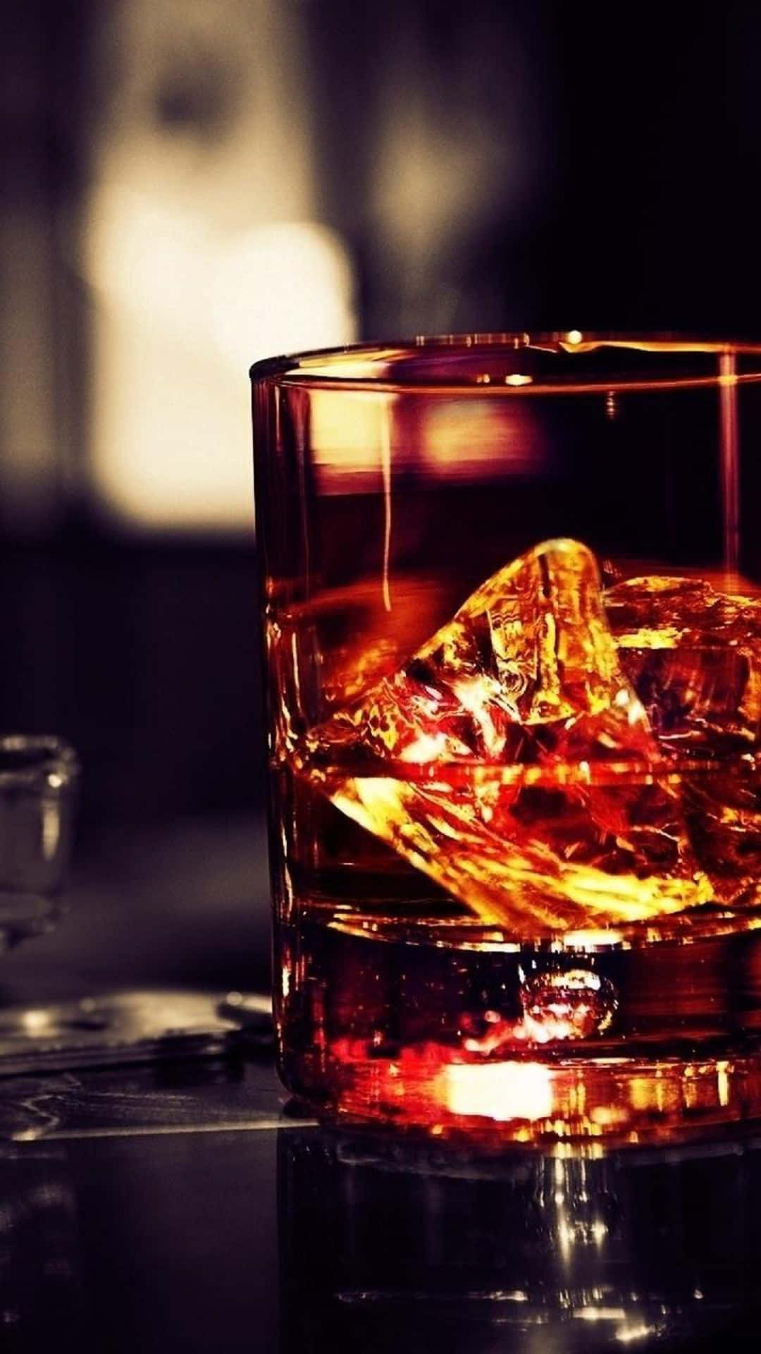A Glass Of Whiskey Is Sitting On A Table