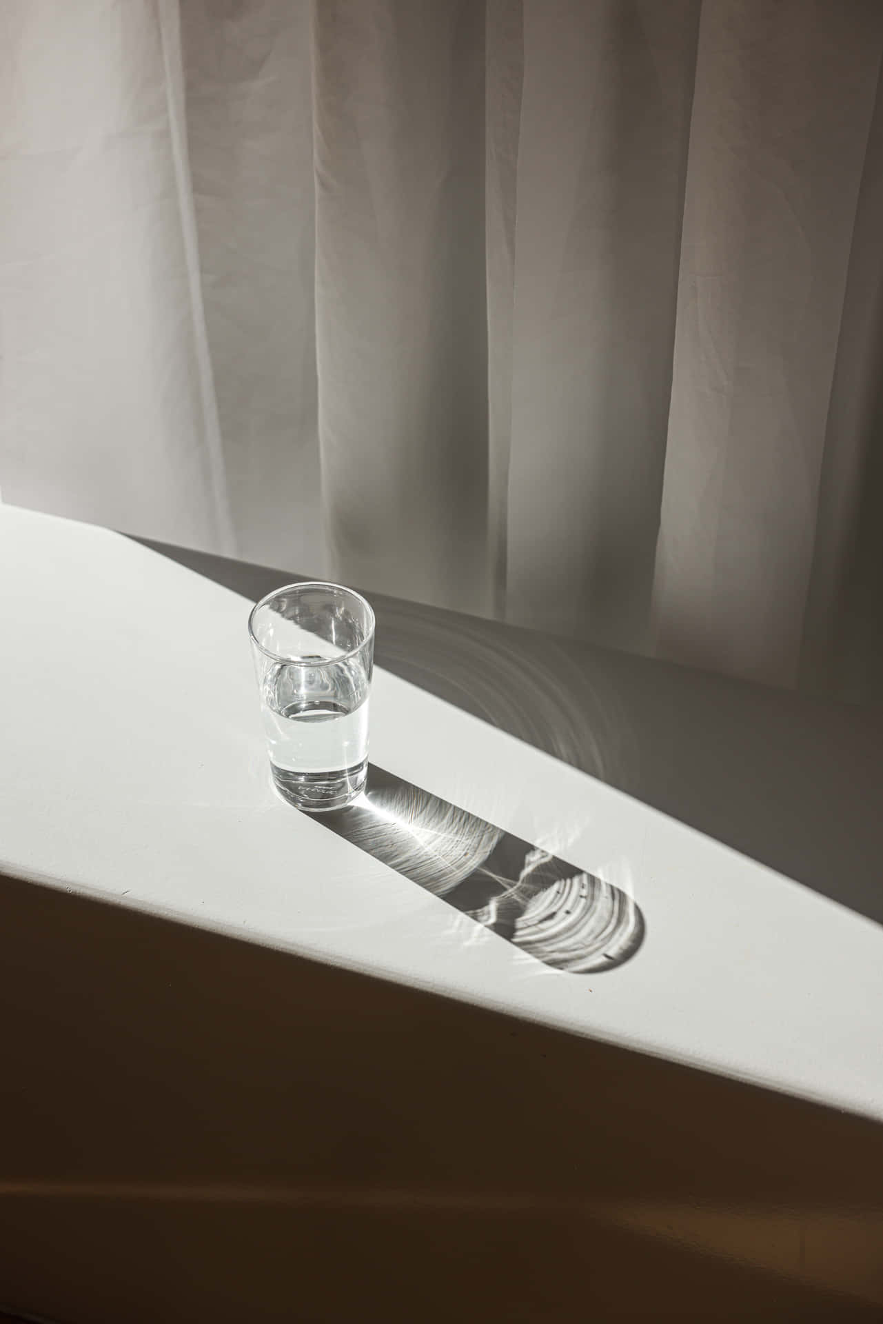 A Glass Of Water On A White Table
