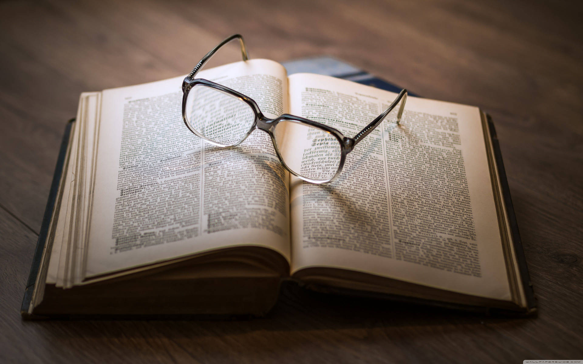 Glasses on top of an open book wallpaper
