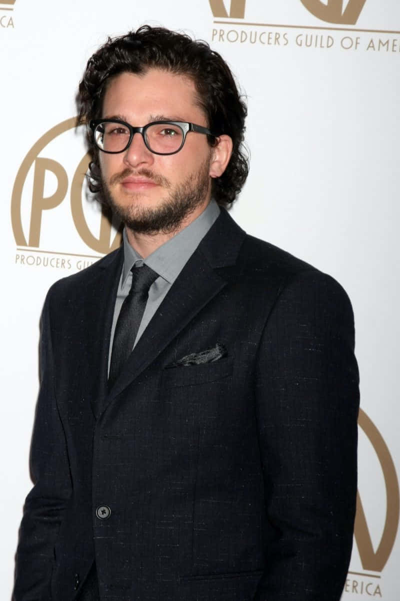 A Man In Glasses Standing On A Red Carpet