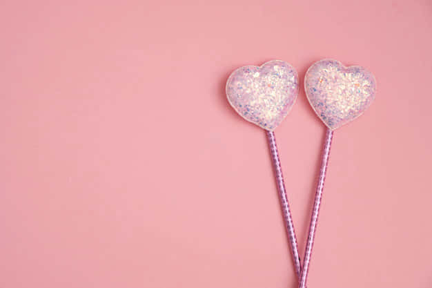 A pink, glittery cascade of heart-shaped confetti Wallpaper