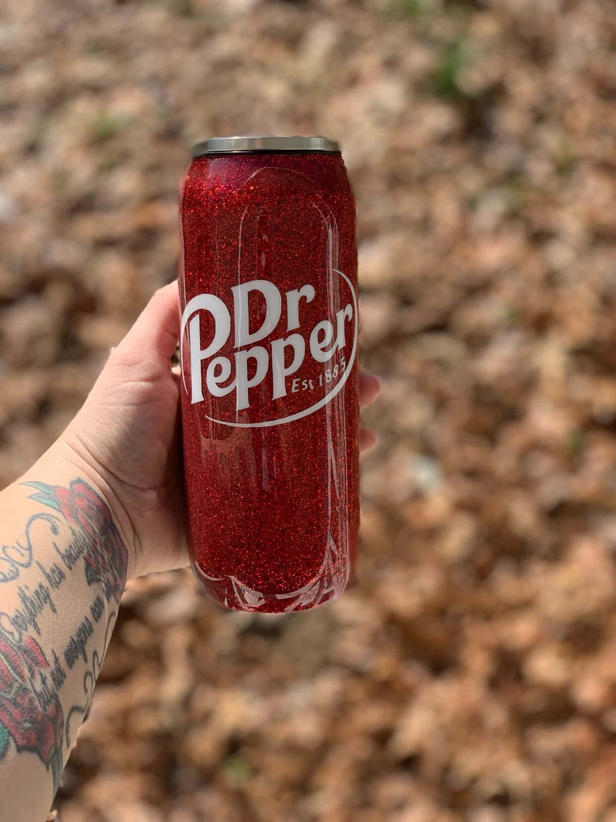 Glittery Red Dr Pepper Can Heldin Hand Wallpaper