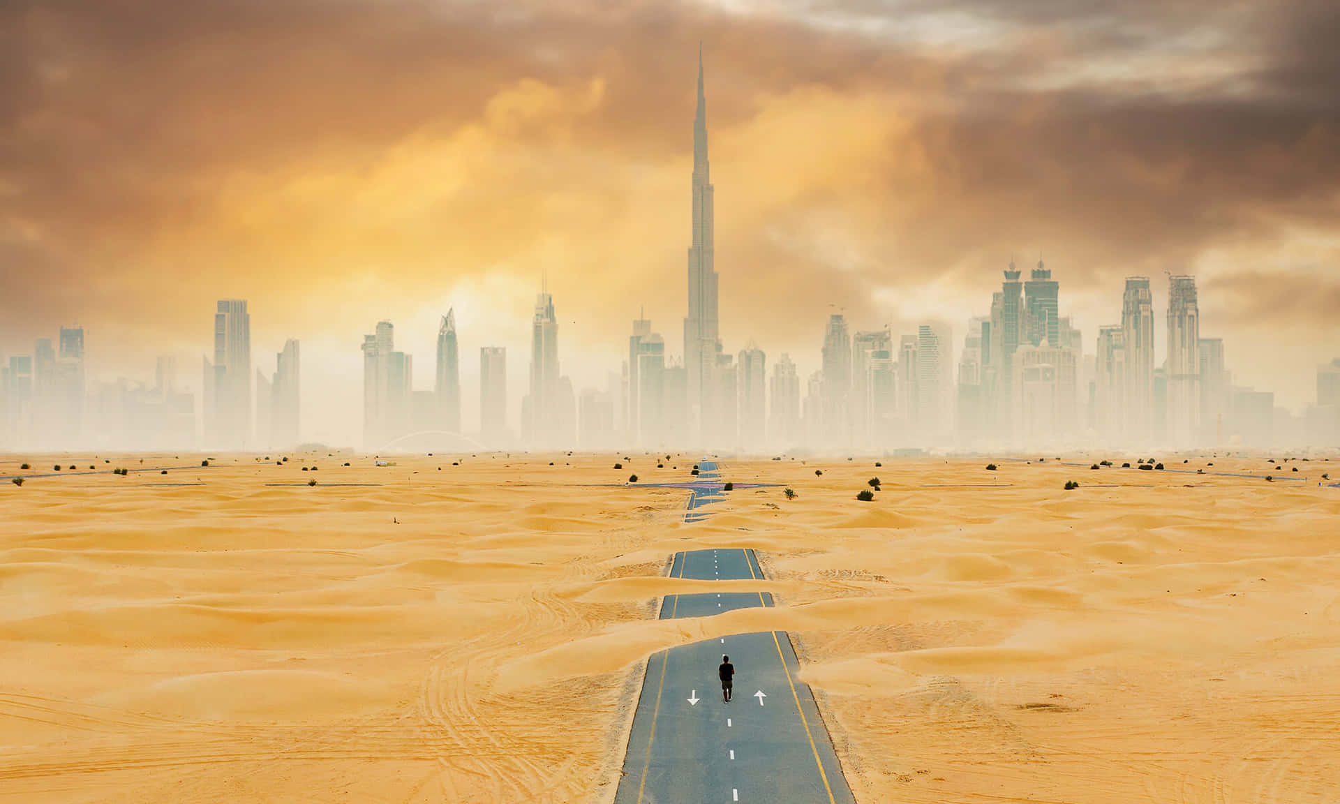 A Man Walking Down A Desert Road With A City In The Background