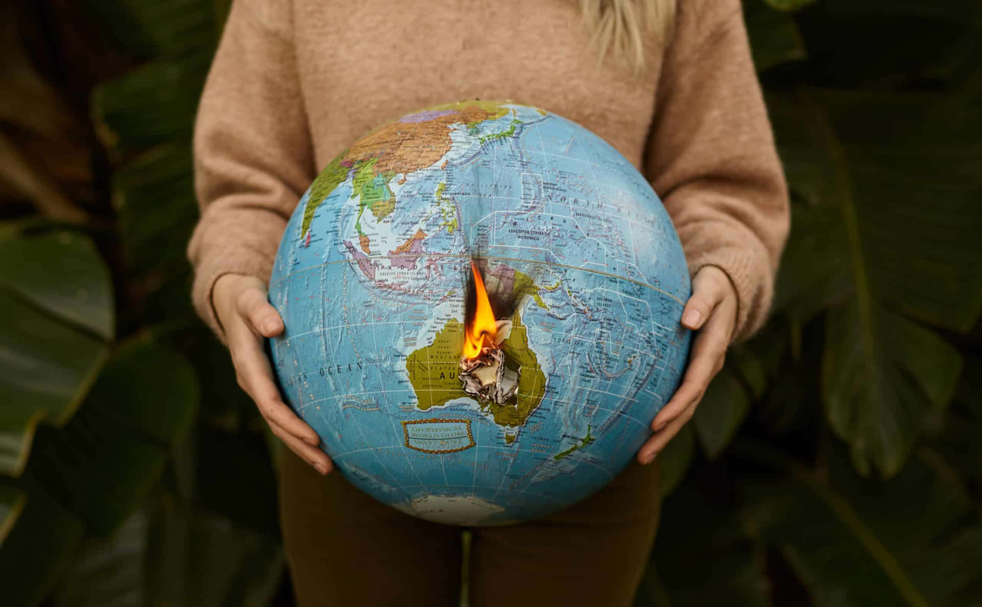 A Woman Holding A Globe With A Fire Burning Inside