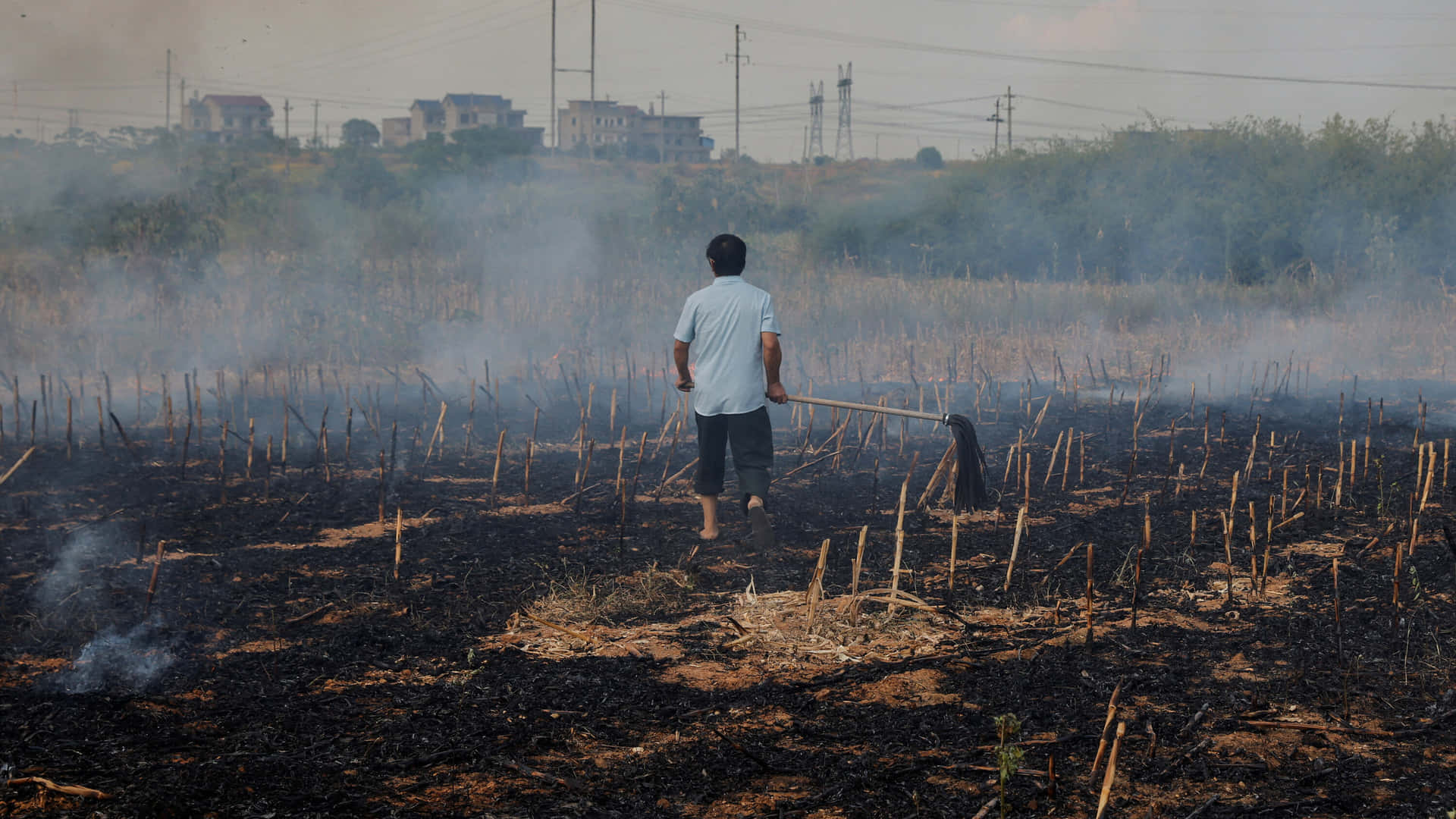 A Man Is Walking Through A Field With Smoke