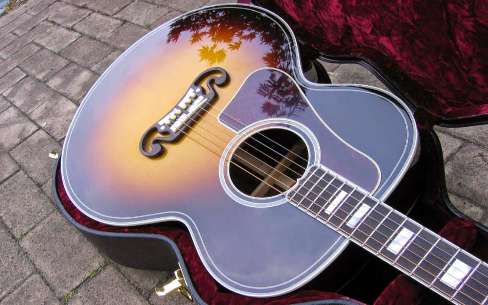 A glossy acoustic guitar, perfect for strumming your best melodies. Wallpaper