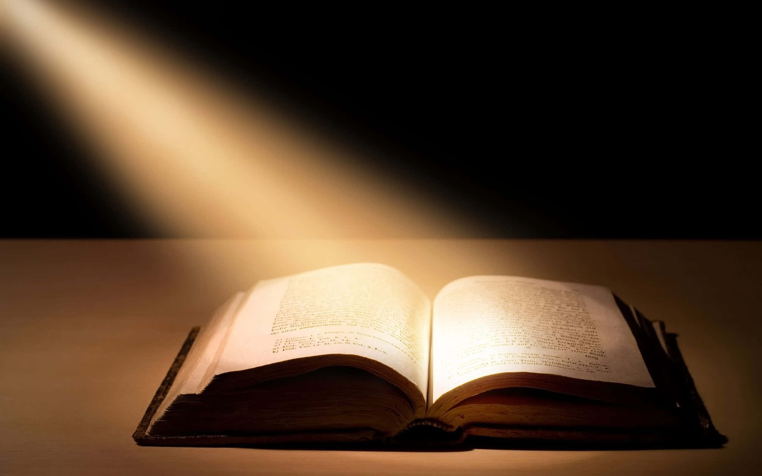 Glowing Holy Bible Amid The Darkness Wallpaper